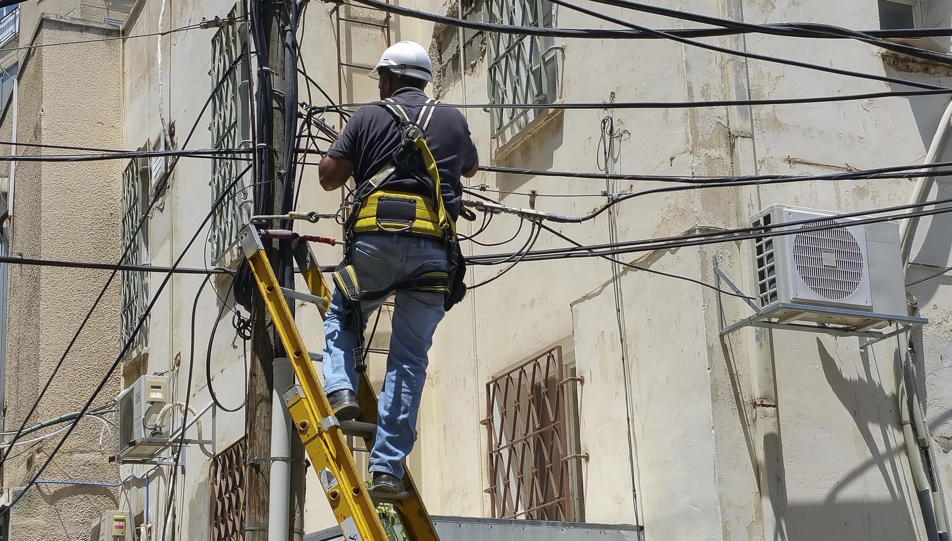 Technician working on elevated telephone cables